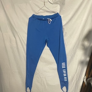 May include: Blue athletic pants with stirrups and a white "FIFA" logo on the right leg.