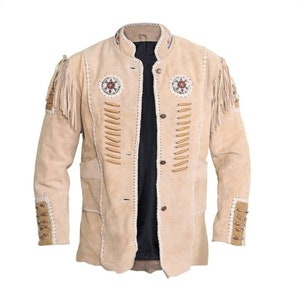 Puede incluir: Chaqueta de ante beige con flecos decorativos en los hombros y las mangas. La chaqueta presenta intrincados detalles de abalorios y costuras, con cierre de botones y dos bolsillos delanteros. El cuello es alzado.