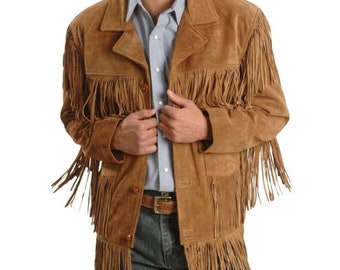 May include: A brown suede jacket with long fringe detailing. The jacket has a button-up front, a notched collar, and pockets. The model is wearing a light blue button-down shirt and blue jeans. The jacket is a western-style garment.
