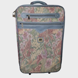 Puede incluir: Una taza de cerámica blanca con un asa negra y el texto "But First, Coffee" en negrita negra. La taza está llena de un líquido oscuro, probablemente café, y se encuentra sobre una superficie de color claro.