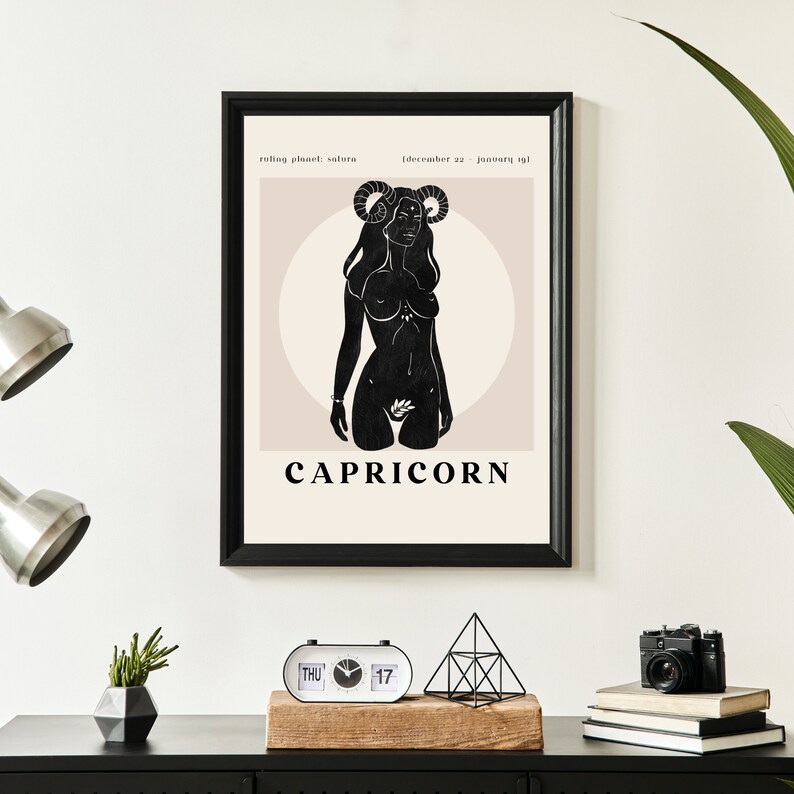 May include: A black and white illustration of a Capricorn zodiac sign with the text "CAPRICORN" below. The illustration is a silhouette of a woman with horns and a flower in her hand. The background is a light beige color with a circle around the woman.