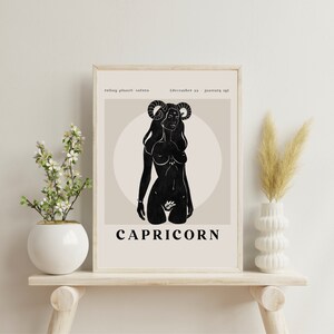 May include: A black and white illustration of a Capricorn zodiac sign. The illustration depicts a woman with horns and a tail, standing in a circle. The text "CAPRICORN" is written below the illustration. The text "ruling planet: saturn" and "december 22 - january 19" is written at the top of the image.