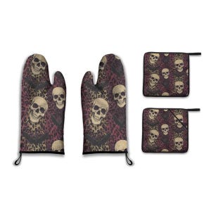 May include: A set of oven mitts and pot holders with a skull and bat pattern. The background has a leopard print design in shades of burgundy and tan. The oven mitts have black hanging loops.
