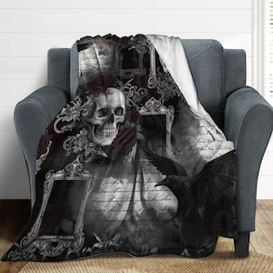 Könnte beinhalten: Eine schwarz-weiße Gothic-Decke mit einem Totenkopf, einem Raben und verzierten Bilderrahmen. Die Decke hat einen Vintage-Look mit floralen Akzenten und Schriftzügen. Das Design ist auf einem weichen, plüschigen Stoff gedruckt.