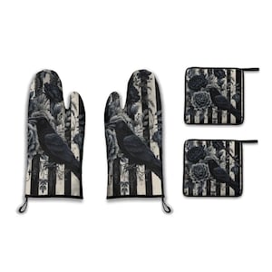 May include: A set of black and white oven gloves and pot holders. The design features a black raven, floral elements, and vertical stripes. The set includes two oven gloves and two pot holders.