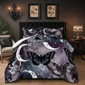 May include: A dark-themed bedding set featuring a repeating pattern of black butterflies, crescent moons, and stars on a purple and gray background. The set includes a comforter and pillowcases, creating a gothic or celestial aesthetic.