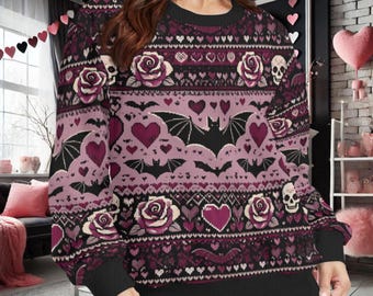 May include: A long-sleeve crewneck sweatshirt featuring a repeating pattern of black bats, pink hearts, white roses, and skulls. The garment has a dark purple and black color palette with a knit-style graphic design across the front and sleeves.