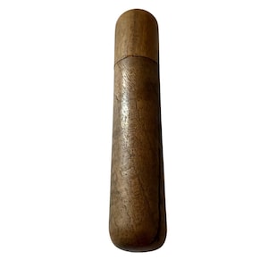Könnte beinhalten: Ein zylindrisches Holzgehäuse mit abgerundeter Oberseite und einer sichtbaren horizontalen Naht, die den Deckel von der Basis trennt. Das Objekt weist eine natürliche braune Holzmaserung mit glatter, polierter Oberfläche auf und steht vertikal.