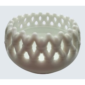 Könnte beinhalten: Eine weiße, dekorative Schale mit Gittermuster. Die Schale hat eine abgerundete Form mit einer Reihe von miteinander verbundenen, oval geformten Öffnungen an den Seiten. Das Innere der Schale ist glatt und weiß.