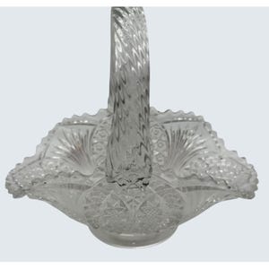 May include: Clear glass basket with a twisted handle. The basket has a scalloped edge and a detailed, textured pattern. The handle is intricately designed, and the basket appears to be made of pressed glass.