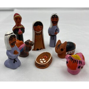 Puede incluir: Un conjunto de figuras de cerámica pintadas a mano para el belén. El conjunto incluye figuras de María, José, el niño Jesús en un pesebre, los tres reyes magos, un camello, un burro y una vaca. Las figuras están pintadas con colores brillantes.