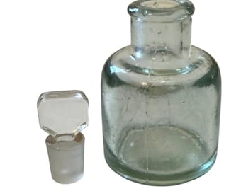Frasco de boticario antiguo de vidrio color aguamarina con tapón de tierra, circa 1900.