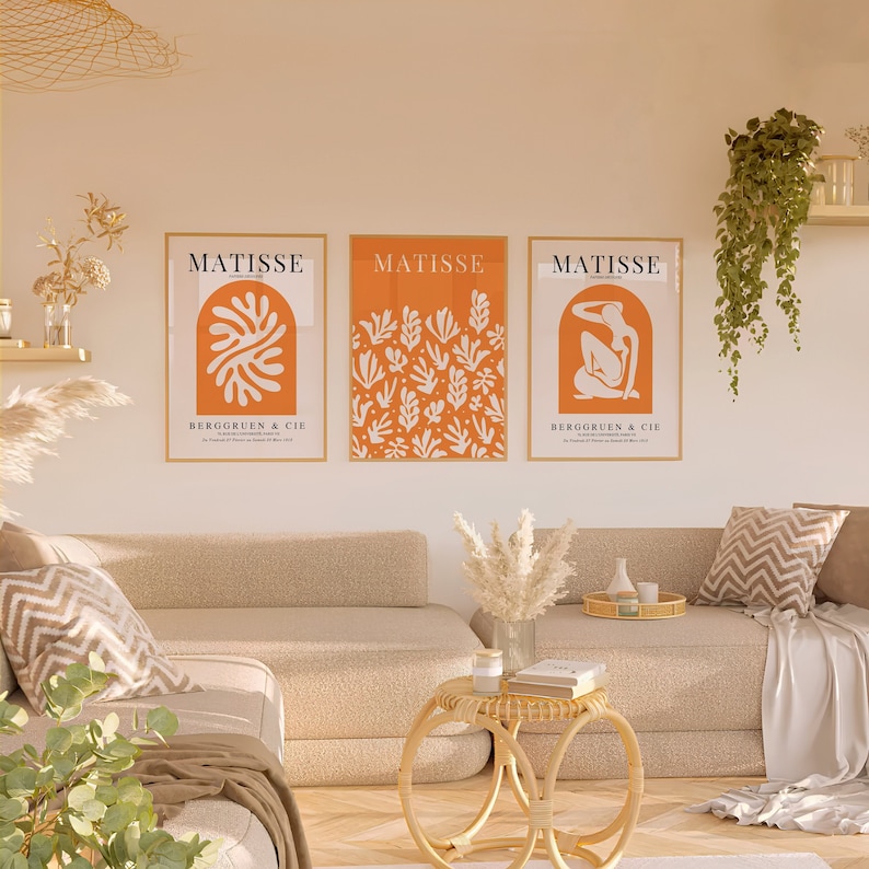 Puede incluir: Tres impresiones de arte enmarcadas con fondo naranja y dise&ntilde;os abstractos blancos. Las impresiones se titulan "Matisse" y presentan el texto "Berggruen & Cie".