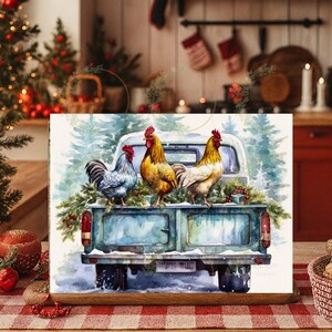 May include: Watercolour print of a vintage teal pickup truck carrying three cockerels. The cockerels are in shades of grey, yellow, and white with red combs. The truck bed is decorated with greenery and snow, set against a backdrop of snowy pine trees.