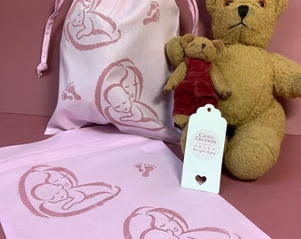 Handprinted drawstring gift bags with baby design.