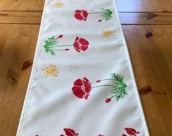 Handprinted soft table runner with red poppy design.