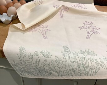 Handprinted buttermilk colour cotton tea towel with flower meadow and seed head design.