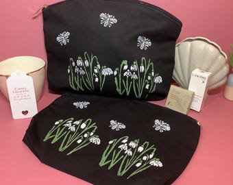 Black zipped pouch/cosmetic bag with snow drop flower design.
