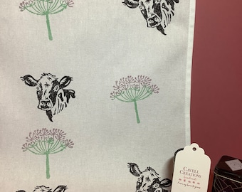 Handprinted cotton tea towel with cow design.