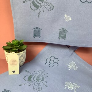 Puede incluir: Dos bolsas de tela lavanda con un dise&ntilde;o de abeja y panal. Las bolsas tienen una abeja en blanco y negro, un panal y un dise&ntilde;o de colmena. Las bolsas est&aacute;n hechas de una tela suave y natural. Las bolsas son perfectas para llevar comestibles, libros u otros art&iacute;culos.