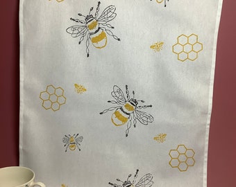 Handprinted cotton tea towels with yellow and black bee and honeycomb design.