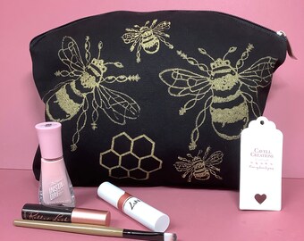 Black and gold zipped pouch/cosmetic bag with bee design.