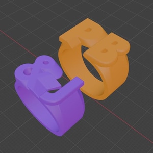 以下が含まれることがあります： 紫とオレンジの2つの3Dレンダリングリング。紫色のリングには文字「L」が、オレンジ色のリングには文字「PB」が表示されています。リングは濃い灰色のグリッドの背景に配置されています。