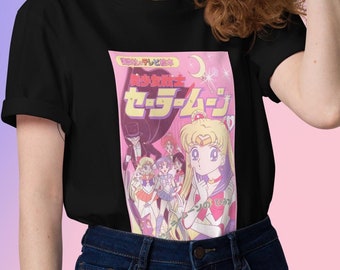 May include: Black t-shirt with a graphic print of the Sailor Moon anime characters. The graphic is in pink and white with Japanese text that reads "Pretty Soldier Sailor Moon".