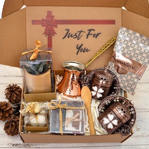 May include: A gift box containing a copper coffee pot, decorative cups and saucers, a small succulent plant, and a package of Turkish coffee. The box is labelled "Just For You".