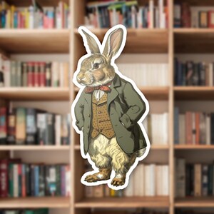 May include: A vintage illustration of a rabbit wearing a green coat, a brown vest, and a red bow tie. The rabbit is standing with its hands in its pockets.