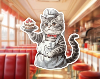 May include: A gray and white tabby cat wearing a chef's hat and apron holds a plate with a layered cake topped with strawberries.