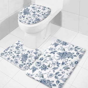 May include: A three-piece bathroom rug set with a floral pattern in shades of blue and white. The set includes a toilet seat cover, a small rug for in front of the toilet, and a larger rug for the floor.