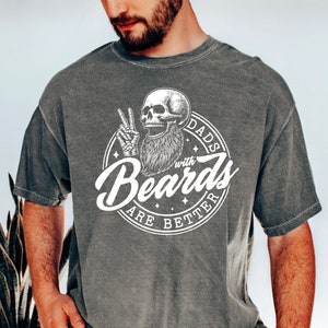 May include: A gray t-shirt with a white graphic of a skull with a beard and the text "Dads with Beards are Better".