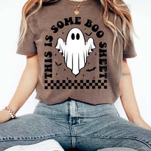 以下が含まれることがあります： 白い幽霊のグラフィックと「This is some boo sheet」というテキストが書かれた茶色のTシャツ。