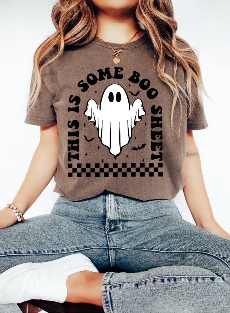 以下が含まれることがあります： 白い幽霊のグラフィックと「This is some boo sheet」というテキストが書かれた茶色のTシャツ。