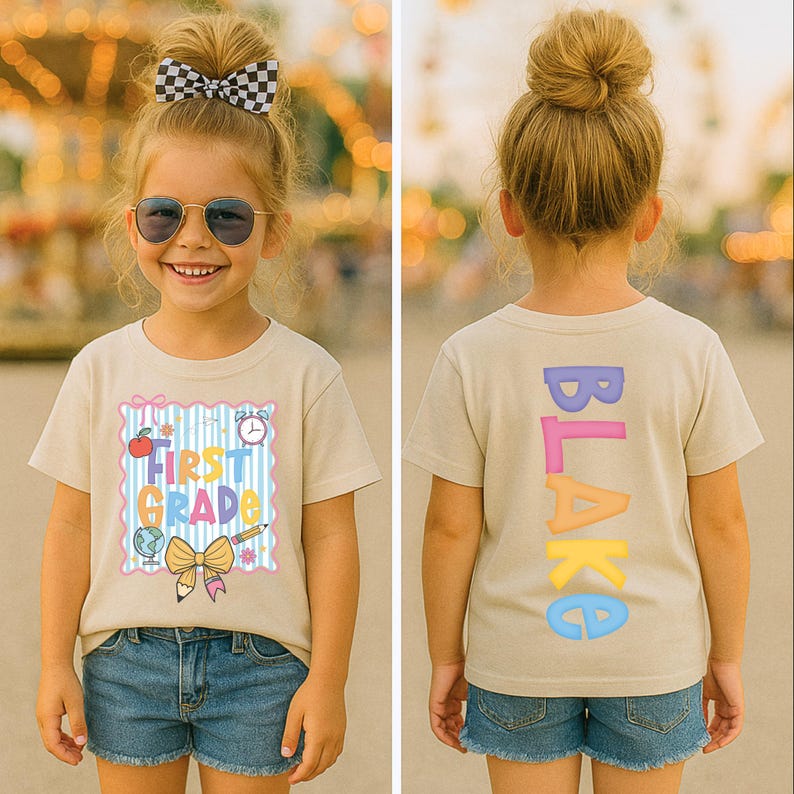 May include: A child wearing a tan t-shirt and denim shorts. The front of the shirt says "FIRST GRADE" with school-themed graphics. The back of the shirt has the name "BLAKE" in colorful letters.