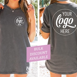 Peut inclure: Un t-shirt gris surdimensionn&eacute; avec un cercle blanc sur le devant et le dos qui dit "Votre logo ici".