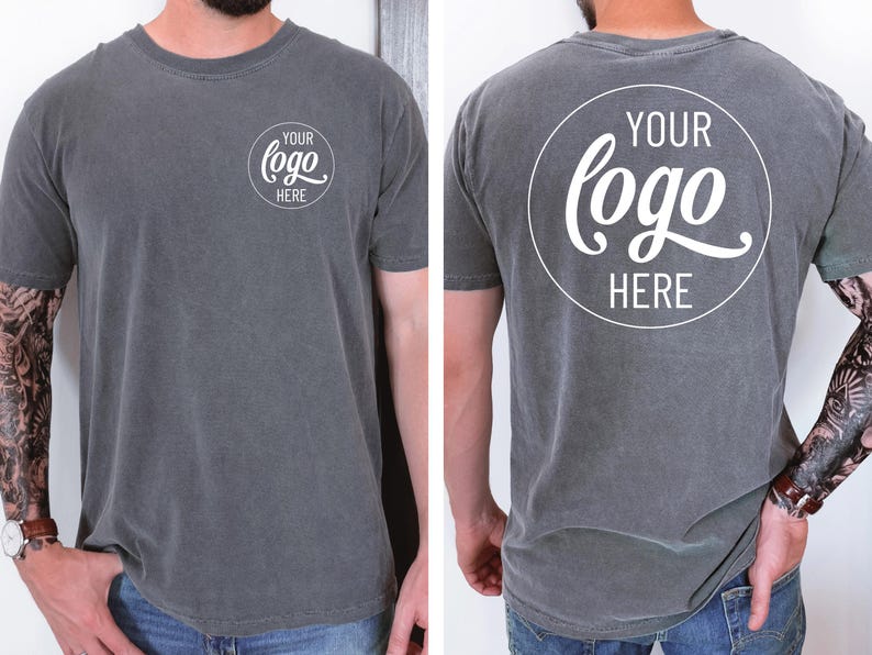 Peut inclure: Un t-shirt gris avec un cercle blanc sur le devant et le dos qui dit "YOUR LOGO HERE" dans une police d'&eacute;criture manuscrite.