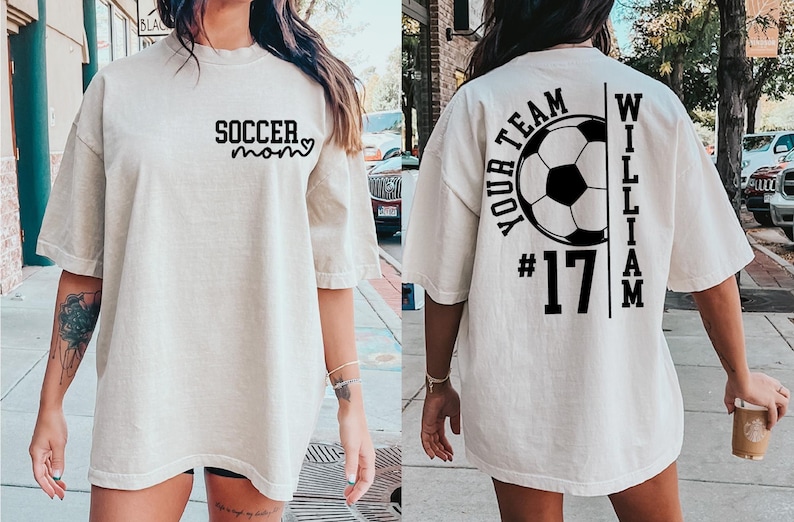 May include: Cream-colored oversized t-shirt with black text. The front reads "SOCCER mom" with a heart. The back features a soccer ball graphic, the words "YOUR TEAM" and "WILLIAM", and the number "17".