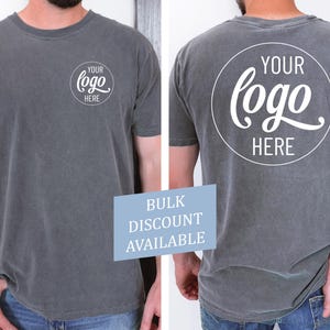 Peut inclure: Un t-shirt gris avec un cercle blanc sur le devant et le dos qui dit "YOUR logo HERE".