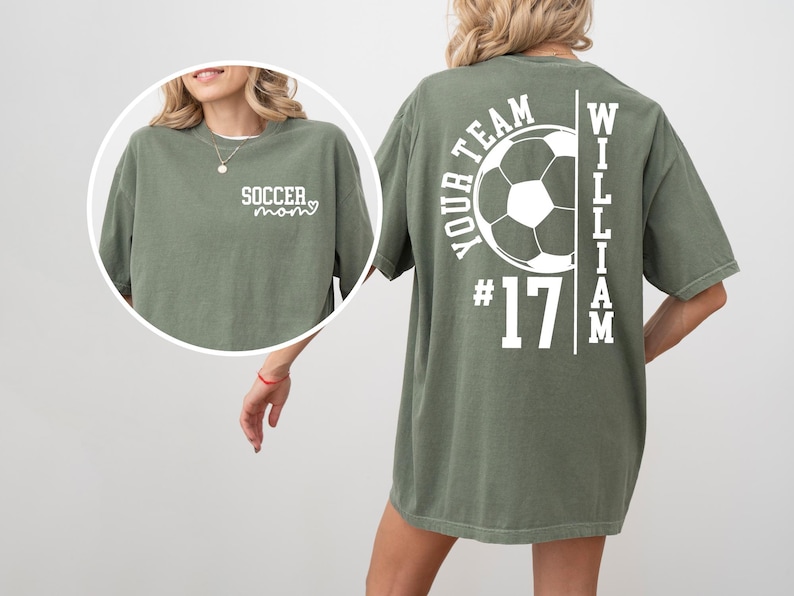 May include: Olive green t-shirt with white text and a soccer theme. The front says "Soccer Mom" with a heart. The back features a soccer ball graphic, the words "Your Team", the number "17", and the name "William".