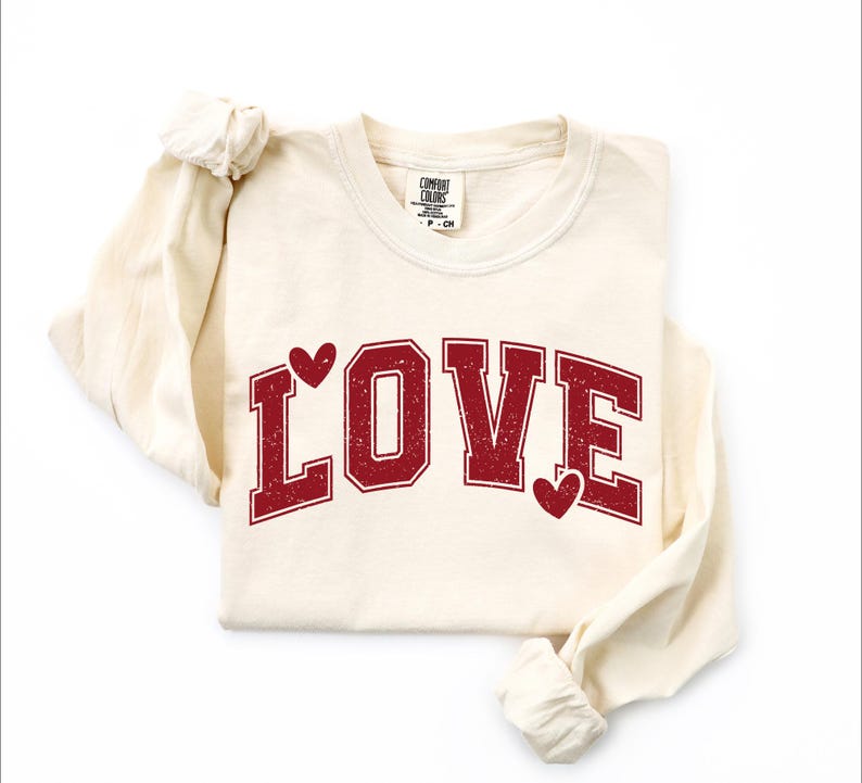 A white long-sleeved t-shirt with the word "LOVE" printed in red letters.