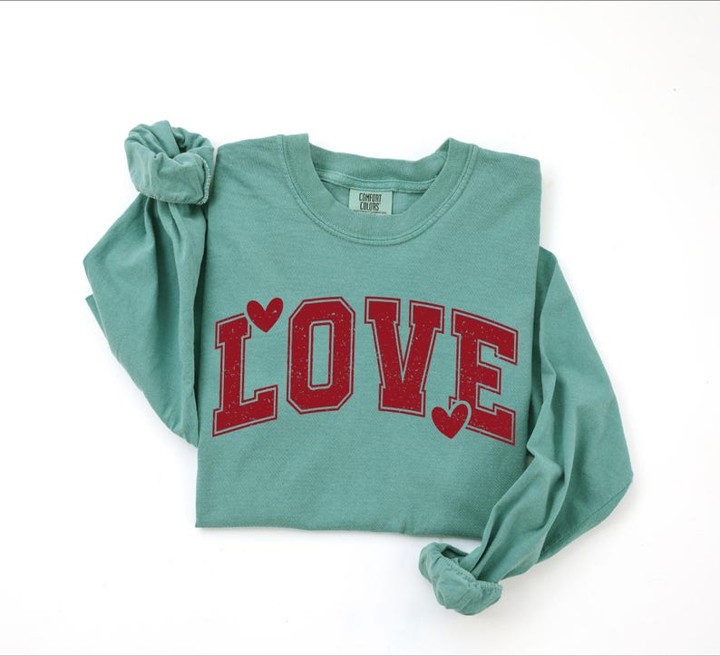 A green long-sleeved t-shirt with the word "LOVE" printed in red letters.