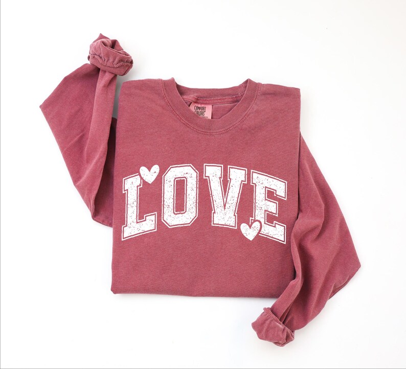 A red long-sleeved t-shirt with the word "LOVE" printed in white letters.