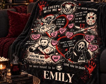 May include: A black fleece blanket featuring horror movie characters and red heart-shaped text bubbles with phrases like Be Creepy With Me, You Slay My Heart, and Love You To Death. The blanket includes the name Emily and various spooky illustrations.