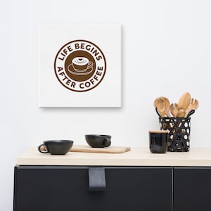May include: A white canvas print with a brown circle that says "Life Begins After Coffee" with a coffee cup and heart design in the center.