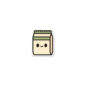 May include: A sticker of a cartoon milk carton with a smiling face. The carton is beige with a green stripe and top, and black eyes. The sticker has a white border.