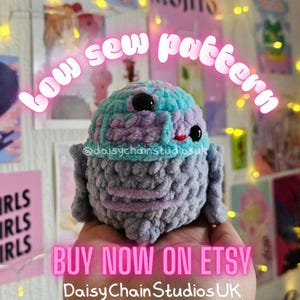 May include: A crocheted plush toy in blue, purple, and grey, with black eyes and a red mouth. The text "low sew pattern" and "BUY NOW ON ETSY" are visible. The plushie is held in a hand. The shop name is DaisyChainStudiosUK.