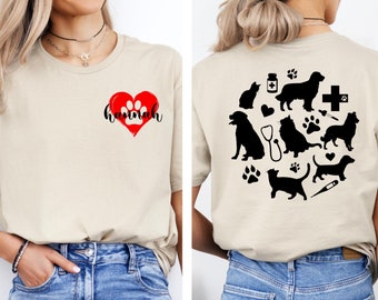 May include: A beige t-shirt with a red heart and the name "Hannah" on the front. The back of the shirt has a black and white design of various animals, including dogs, cats, and a stethoscope.