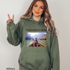 May include: A green hooded sweatshirt with a photo of a couple in a boat on a lake. The text "YOUR PHOTO HERE" is printed above the photo.